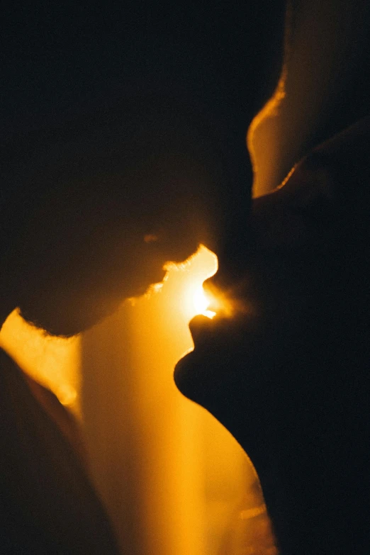 closeup image of the silhouette of two people kissing