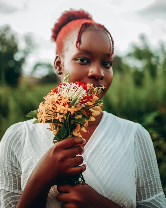 a woman with red hair holds a bouquet of flowers