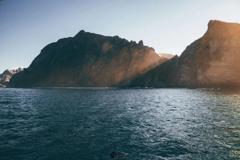 large rocks are on the side of the ocean