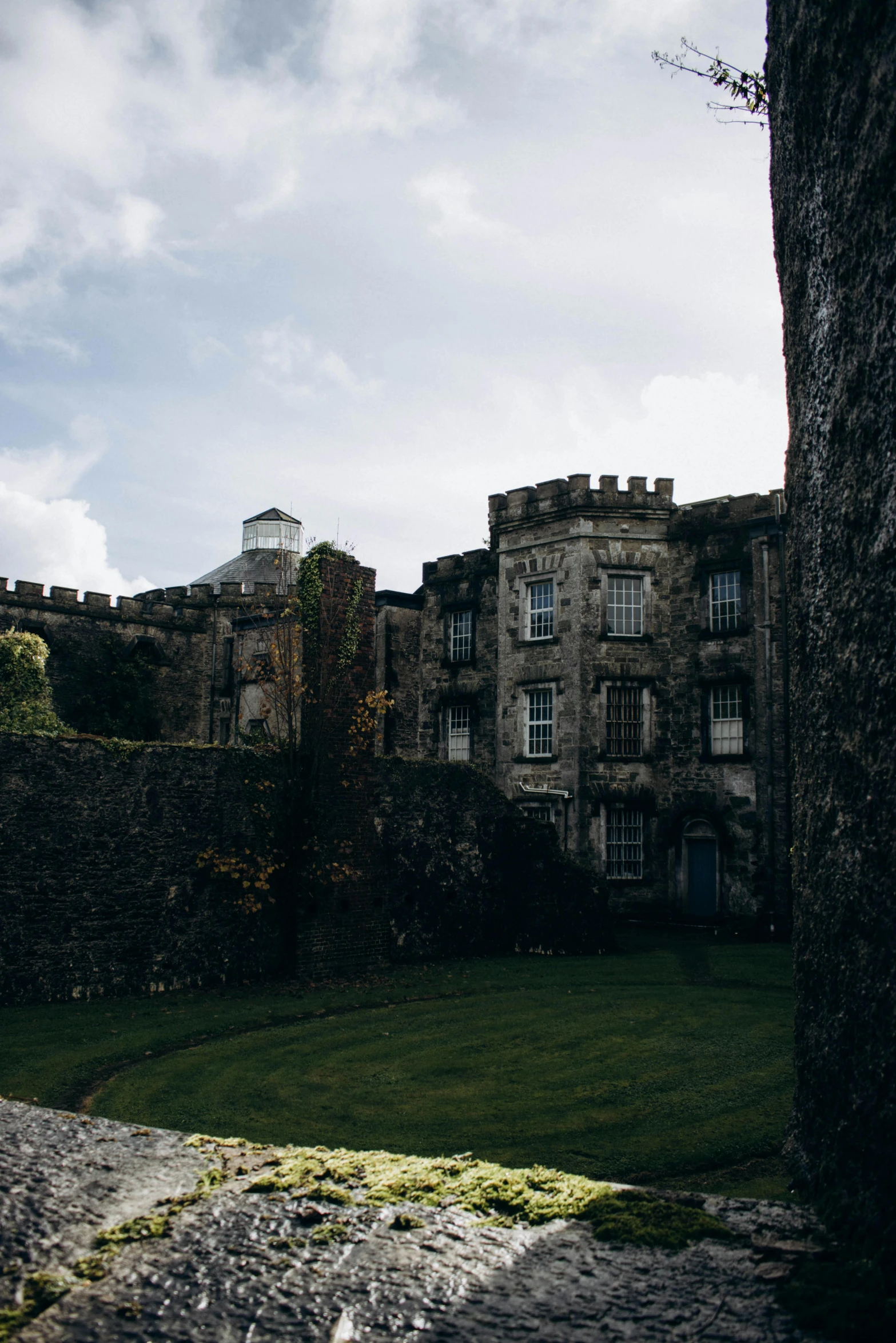 a long stone wall by a large castle