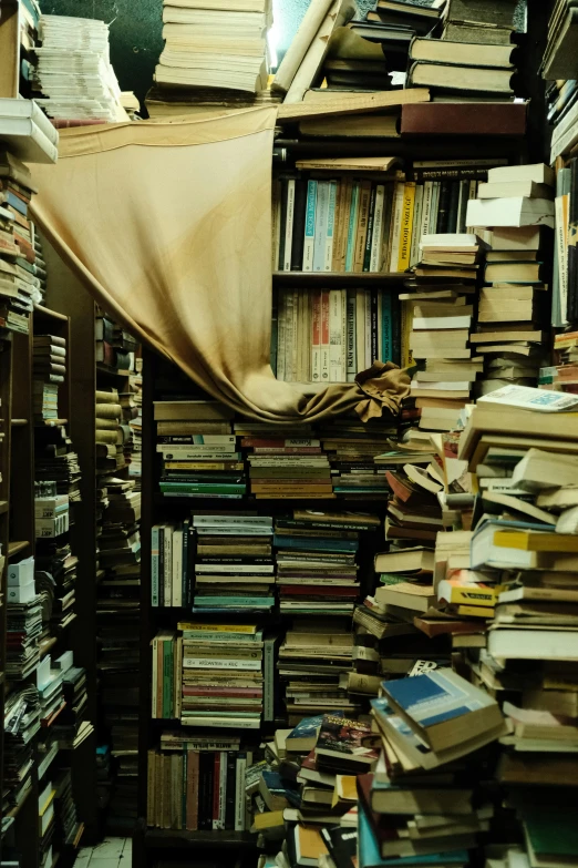 a large pile of books stacked up against a wall