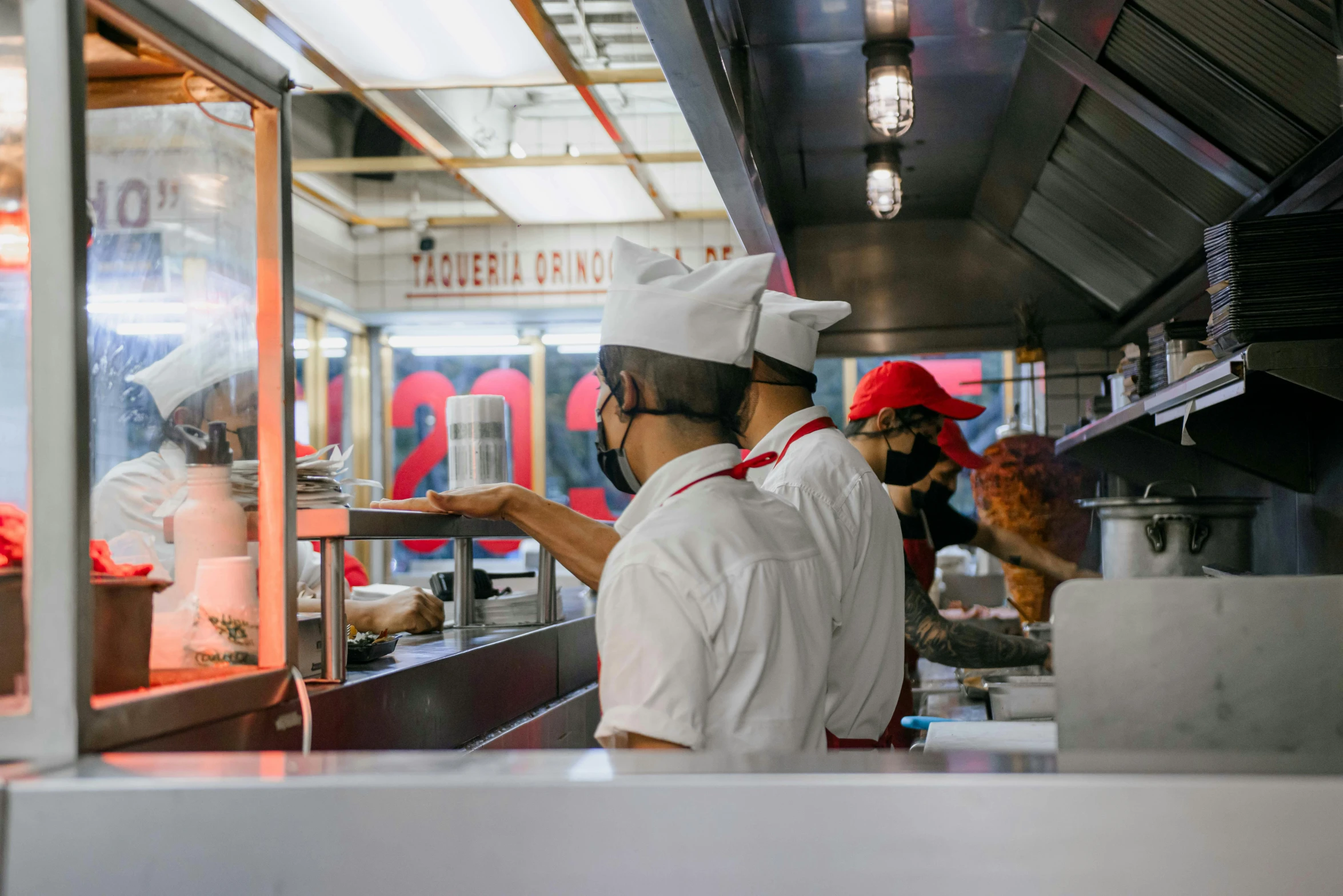 workers are preparing food inside of a restaurant