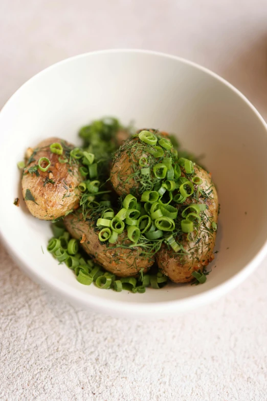 a white bowl containing green pea and some kind of meat