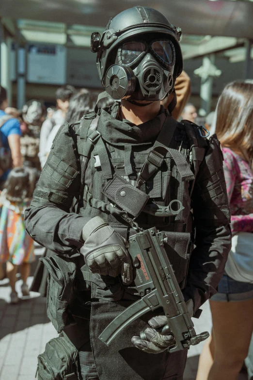 a man is dressed as a soldier holding a gun and wearing gas mask