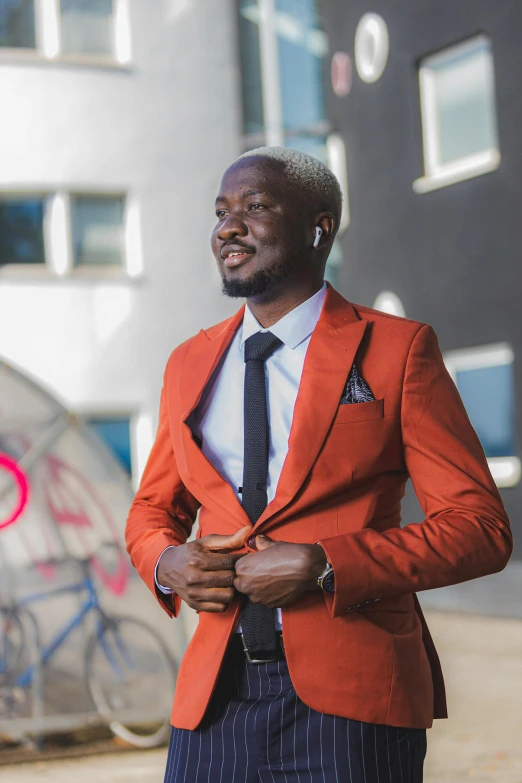 a man in an orange suit standing near a bicycle