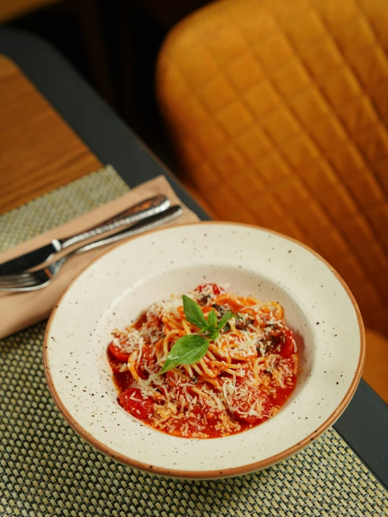 a bowl filled with spaghetti and sauce next to a fork