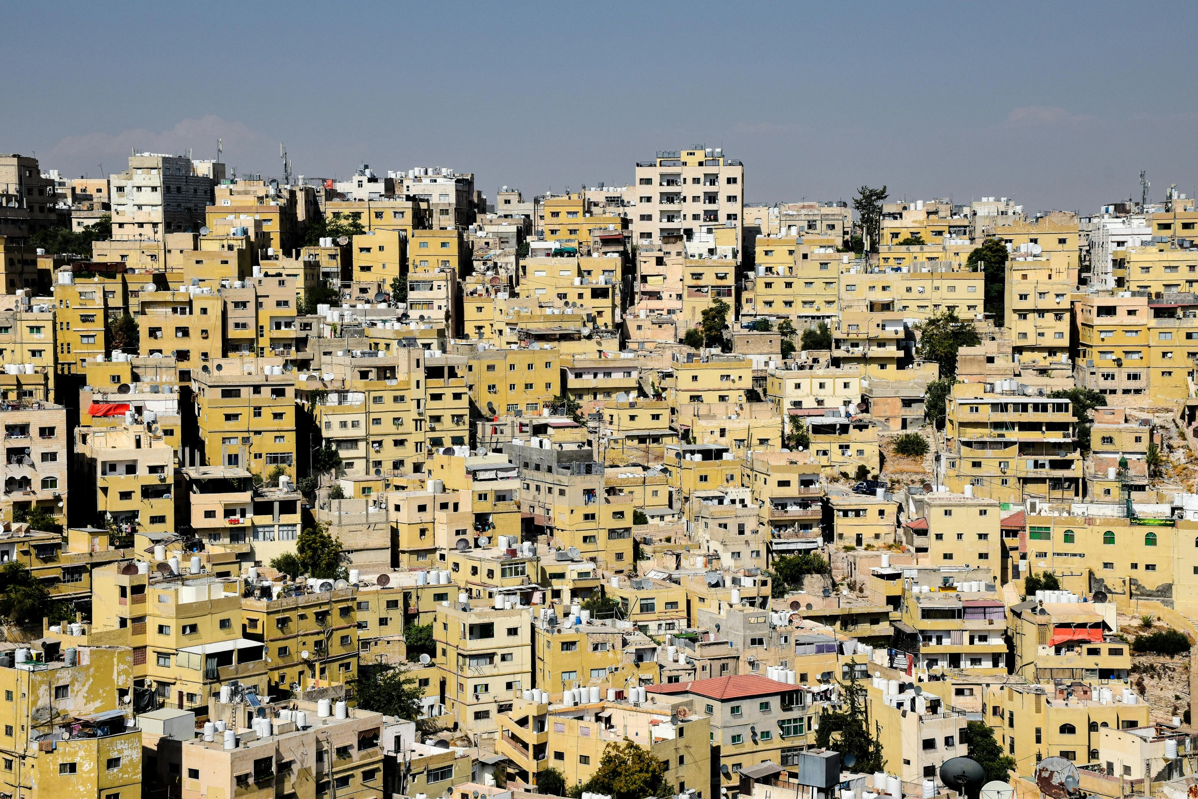 many yellow buildings are seen with blue skies in the background