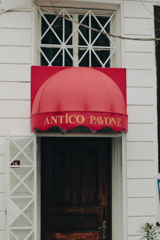 an outside entrance to a building with a red umbrella