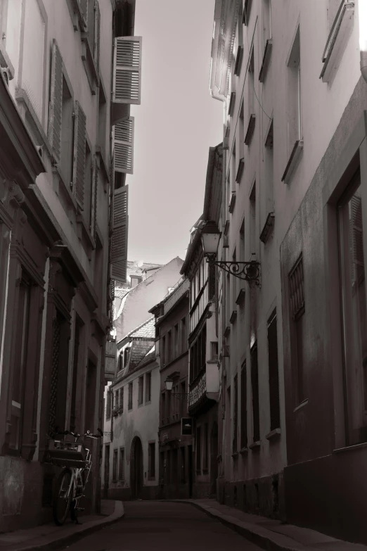 a narrow street with stone buildings and a motorcycle parked