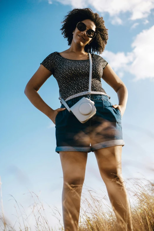 woman standing on a grass covered field holding a camera