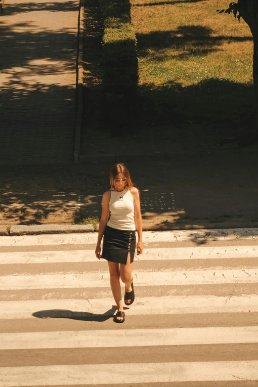 a woman walking up the street with her purse on her shoulder