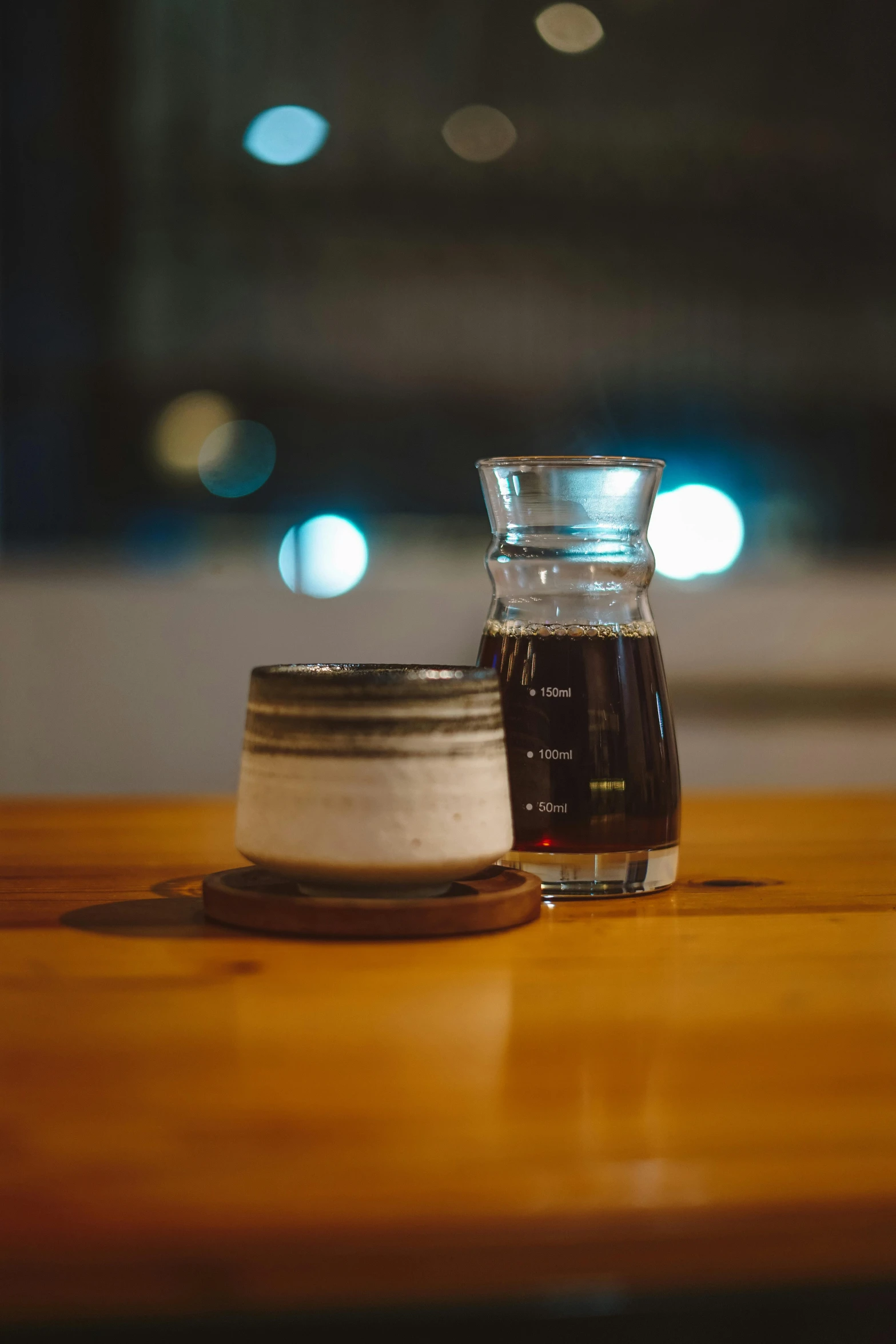 a small vase and cup sit on the table