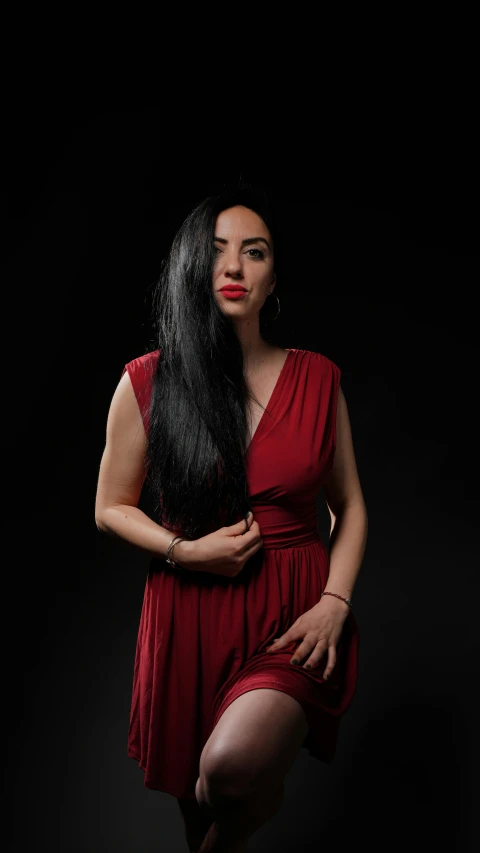 woman in a red dress and black background with long dark hair