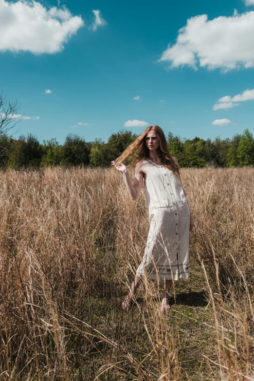 a young woman is playing in the grass with her long hair