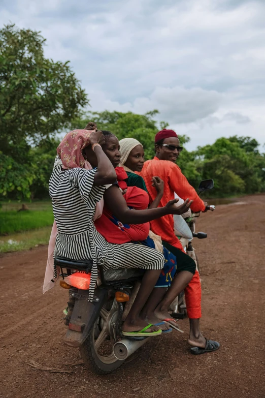 a group of three women riding on the back of a motorcycle