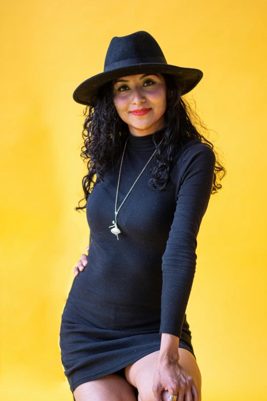 a young woman is posing in a black dress