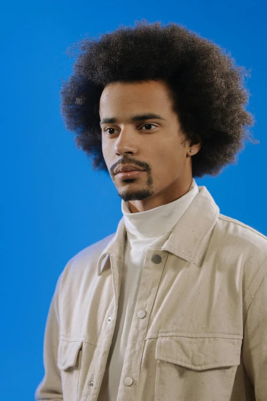 a young man in a white shirt with an afro