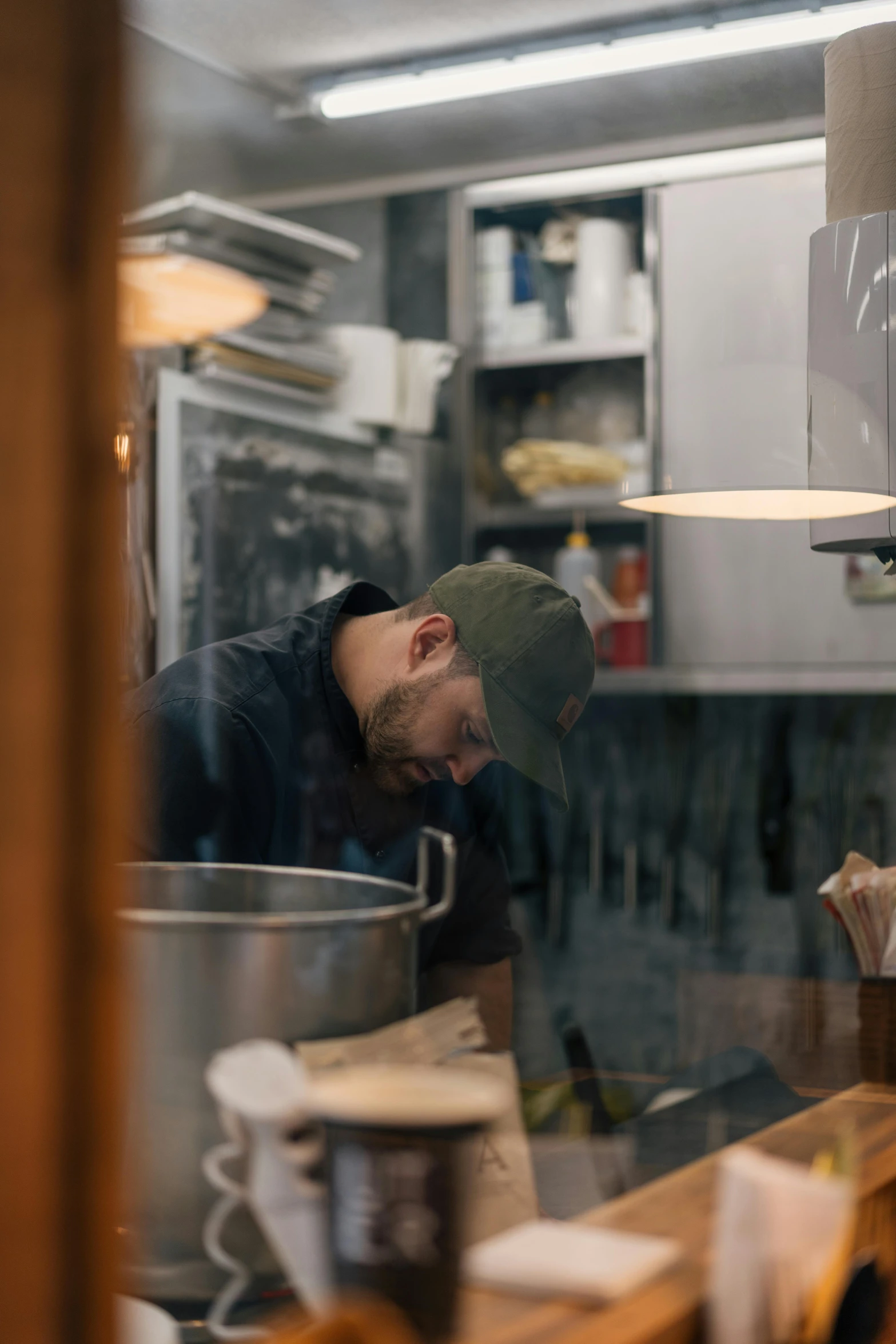 a man standing in a kitchen with a hat