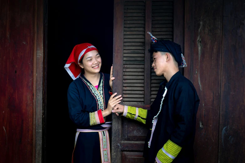 two people are smiling while talking in front of a door