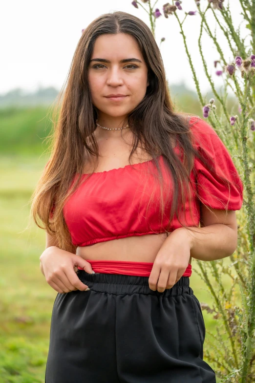 girl posing in front of the camera in the middle of a field