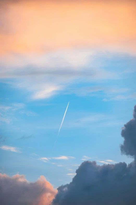 an airplane flies in the sky while clouds loom below