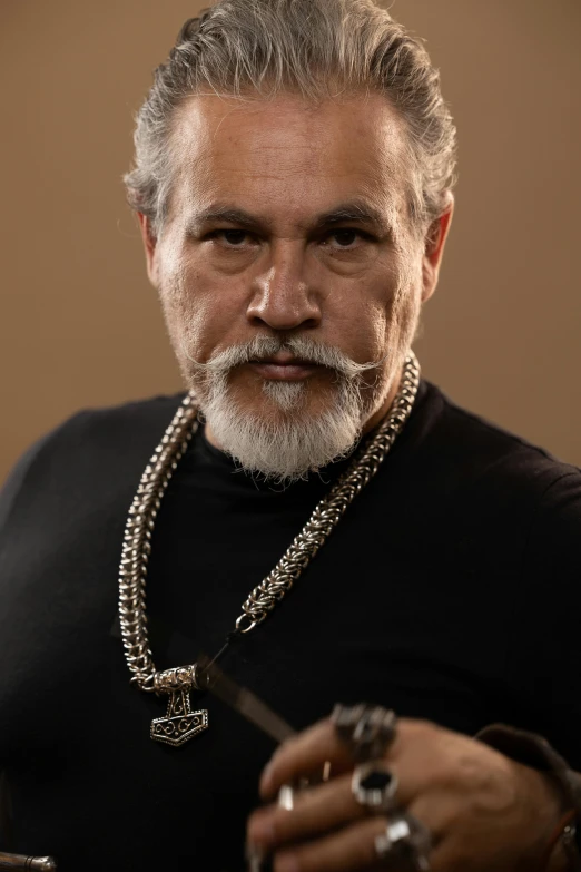 a man in black shirt with a silver chain