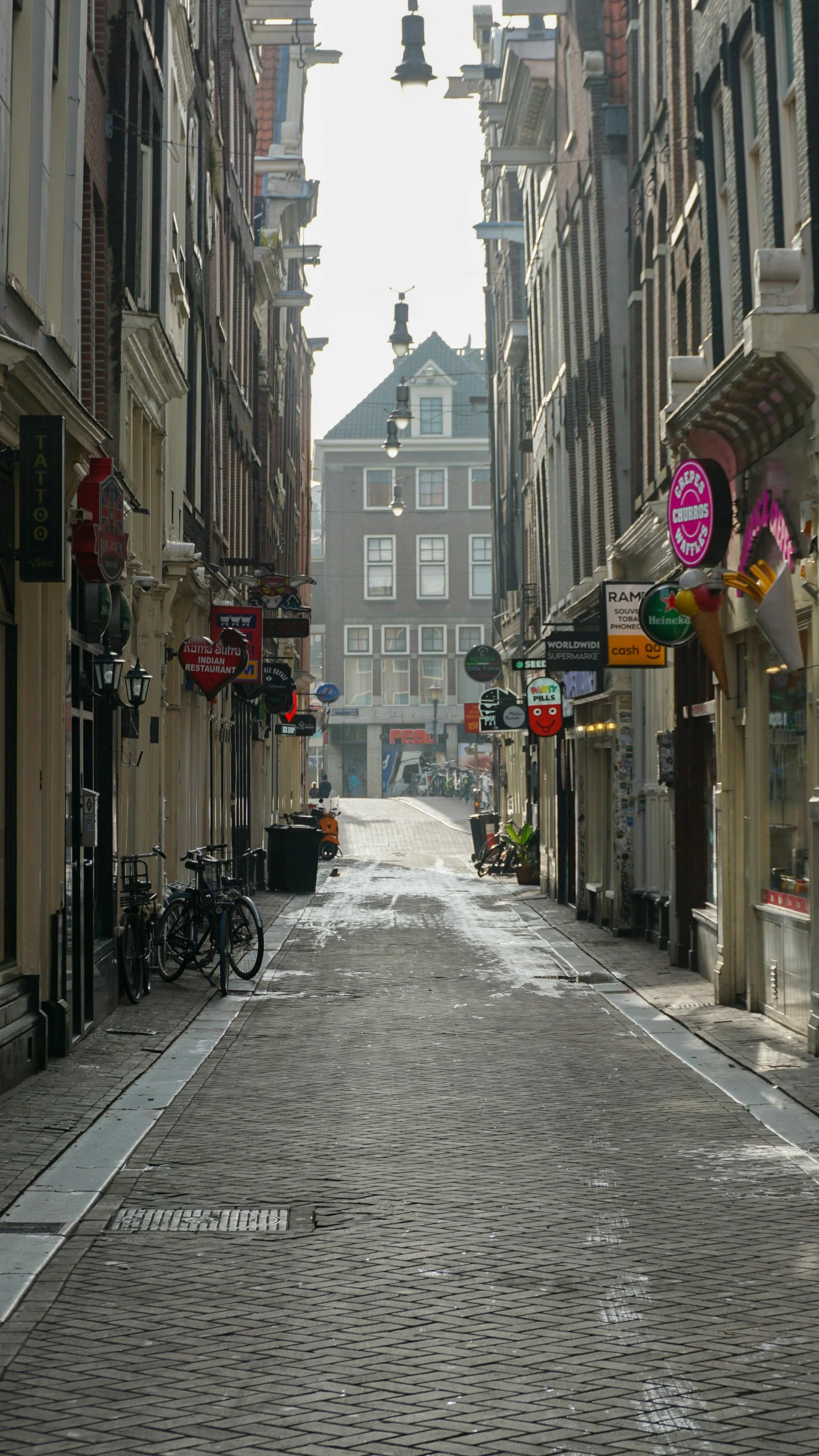 a long, narrow street with shops and bikes