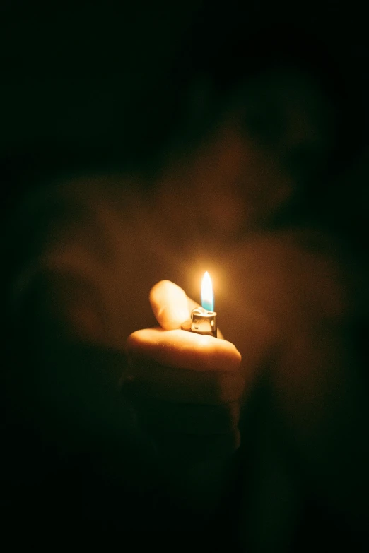 a close up of a candle in someones hand