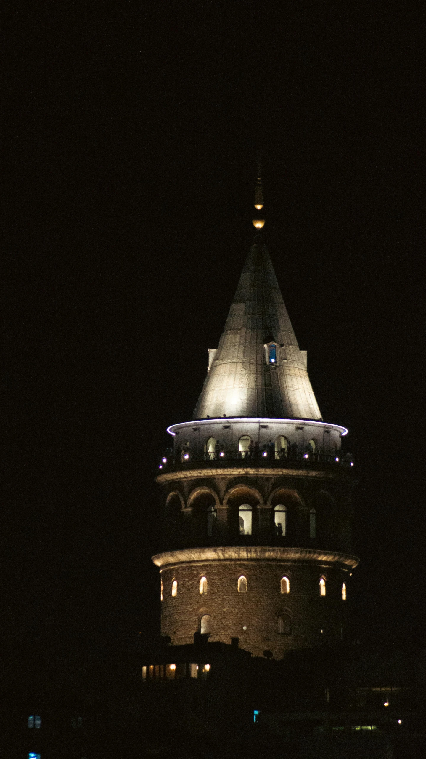 the large round building has a clock tower at night