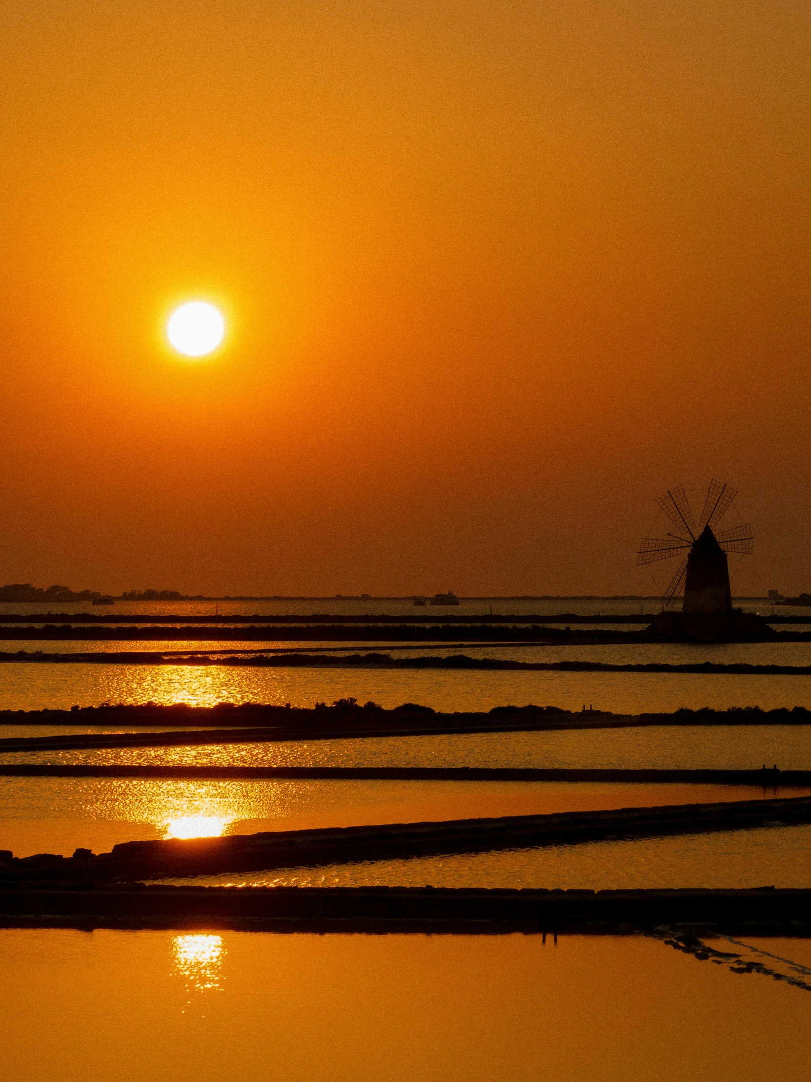 the sun sets over a large body of water