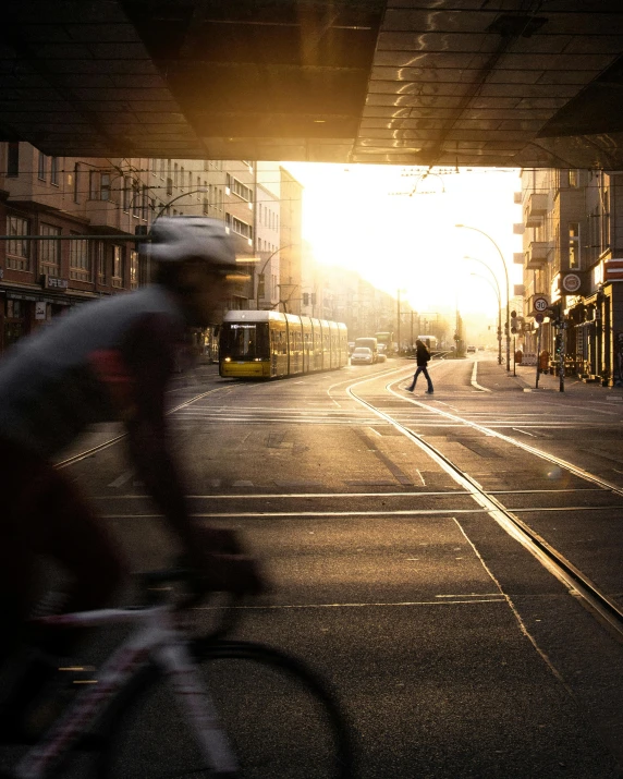 a person riding a bike in a city with a sunset