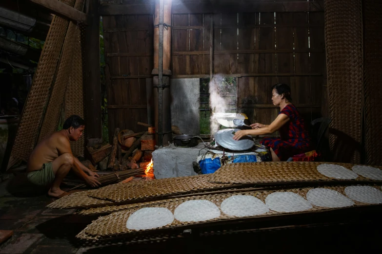 people sitting in front of a bed with food on it