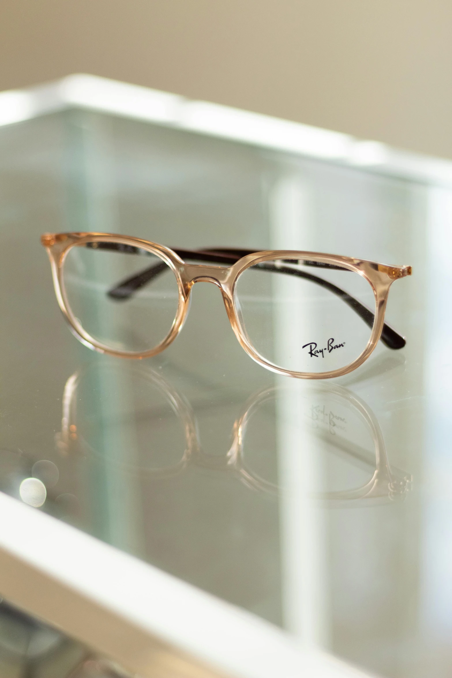 a pair of glasses with clear frames sitting on a glass table