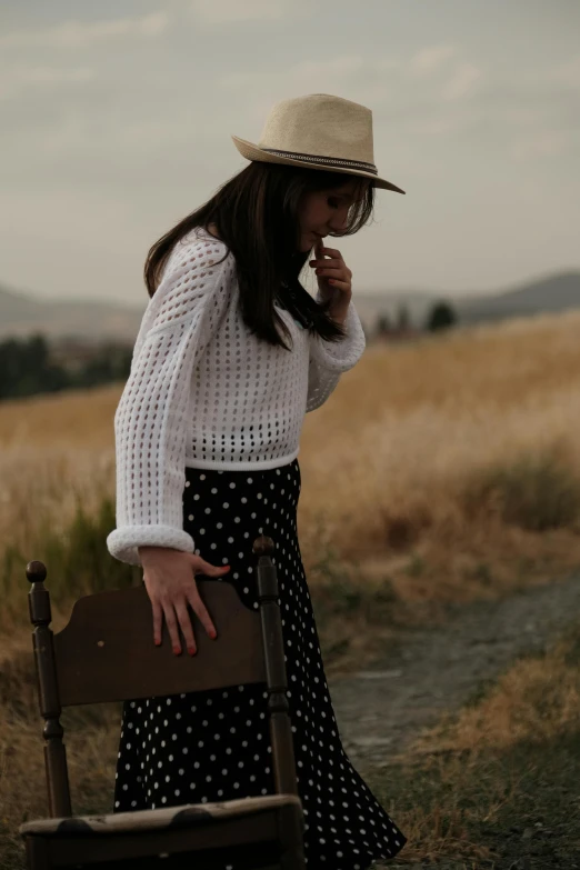 a woman is standing with a wooden chair