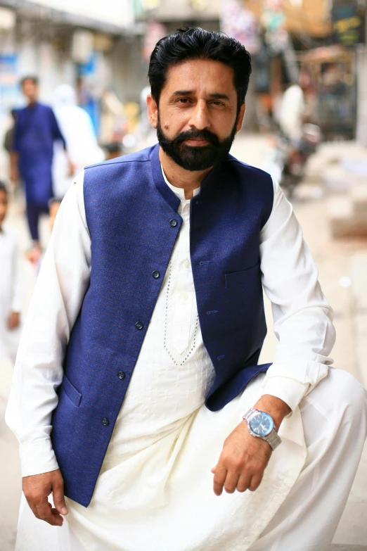 a man sitting in front of a street while wearing a white shirt