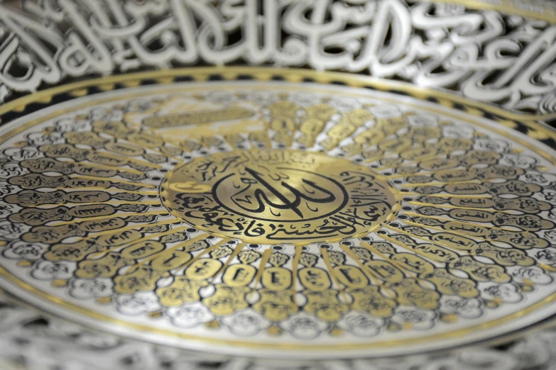 an intricately decorated plate has the word al - quran in cursive writing