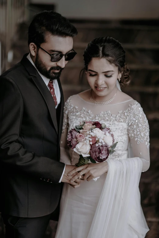 a couple are posing in their wedding dresses