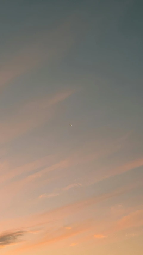 a kite is in the air flying above some clouds