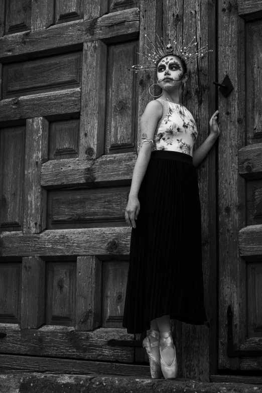 a young woman is standing outside of an old barn door