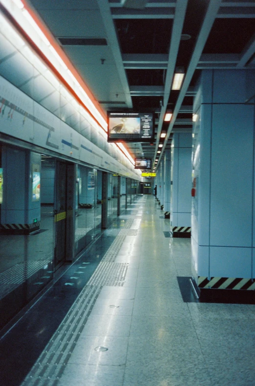 a long, empty subway station with lights on