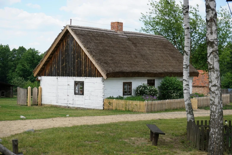 a white house with a brown thatched roof