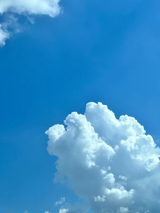 large fluffy clouds float against a blue sky