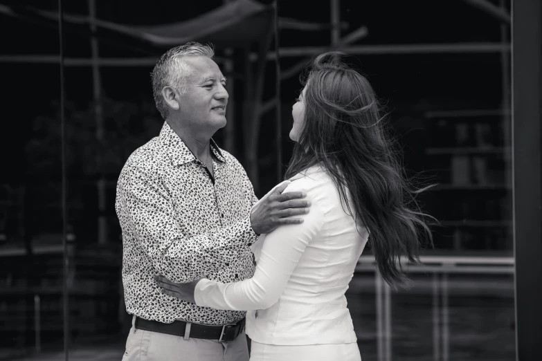 a man is hugging his wife as they are dancing in the street