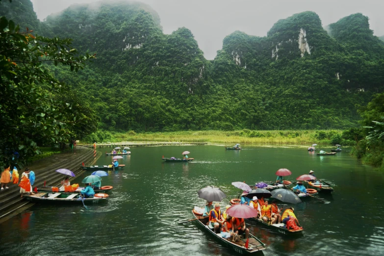 several boats float on a body of water while surrounded by mountains