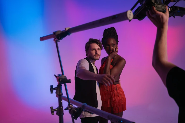 a man and woman with red clothing hold their hand over the head of a camera while posing