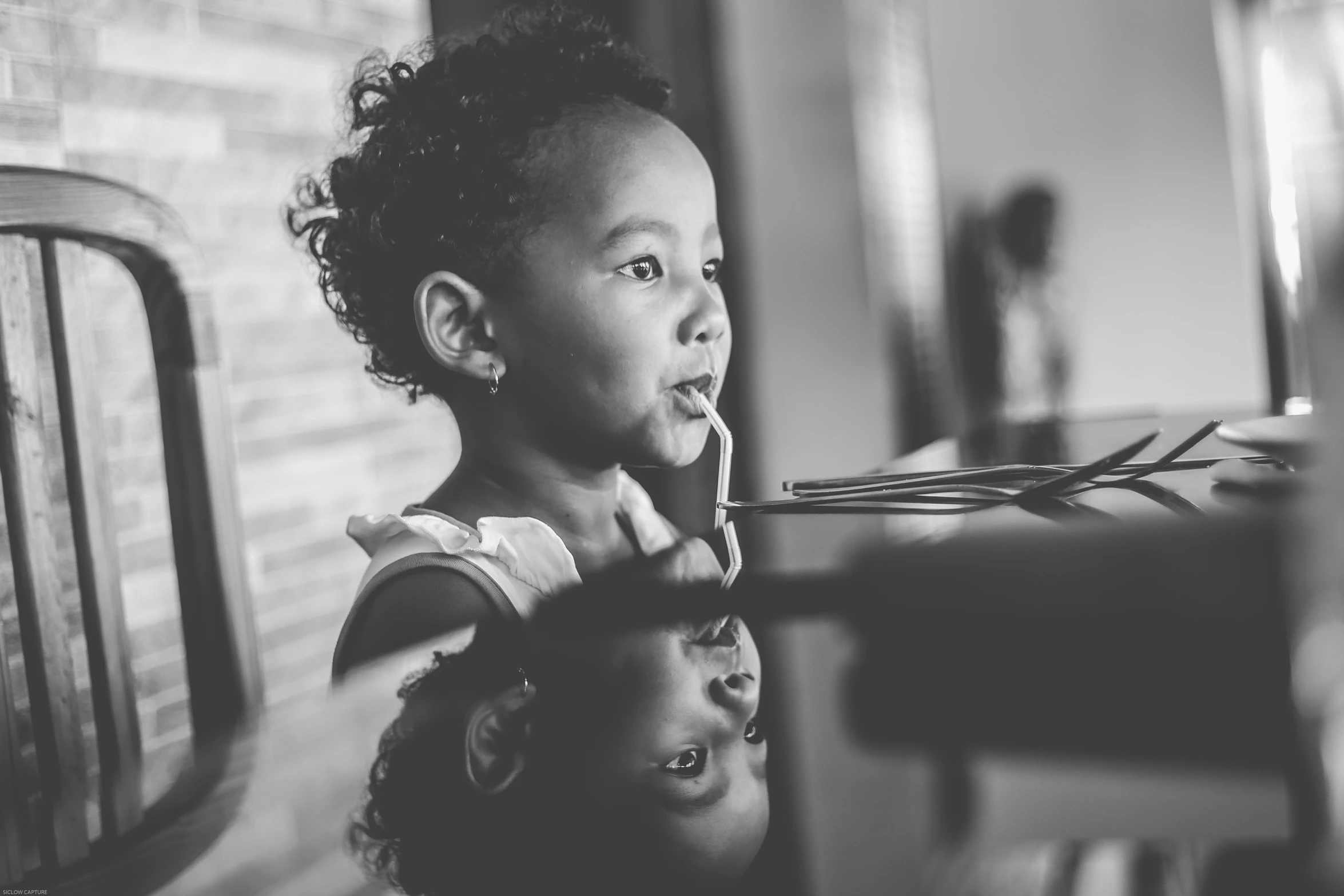 a little girl getting her hair combed by an adult