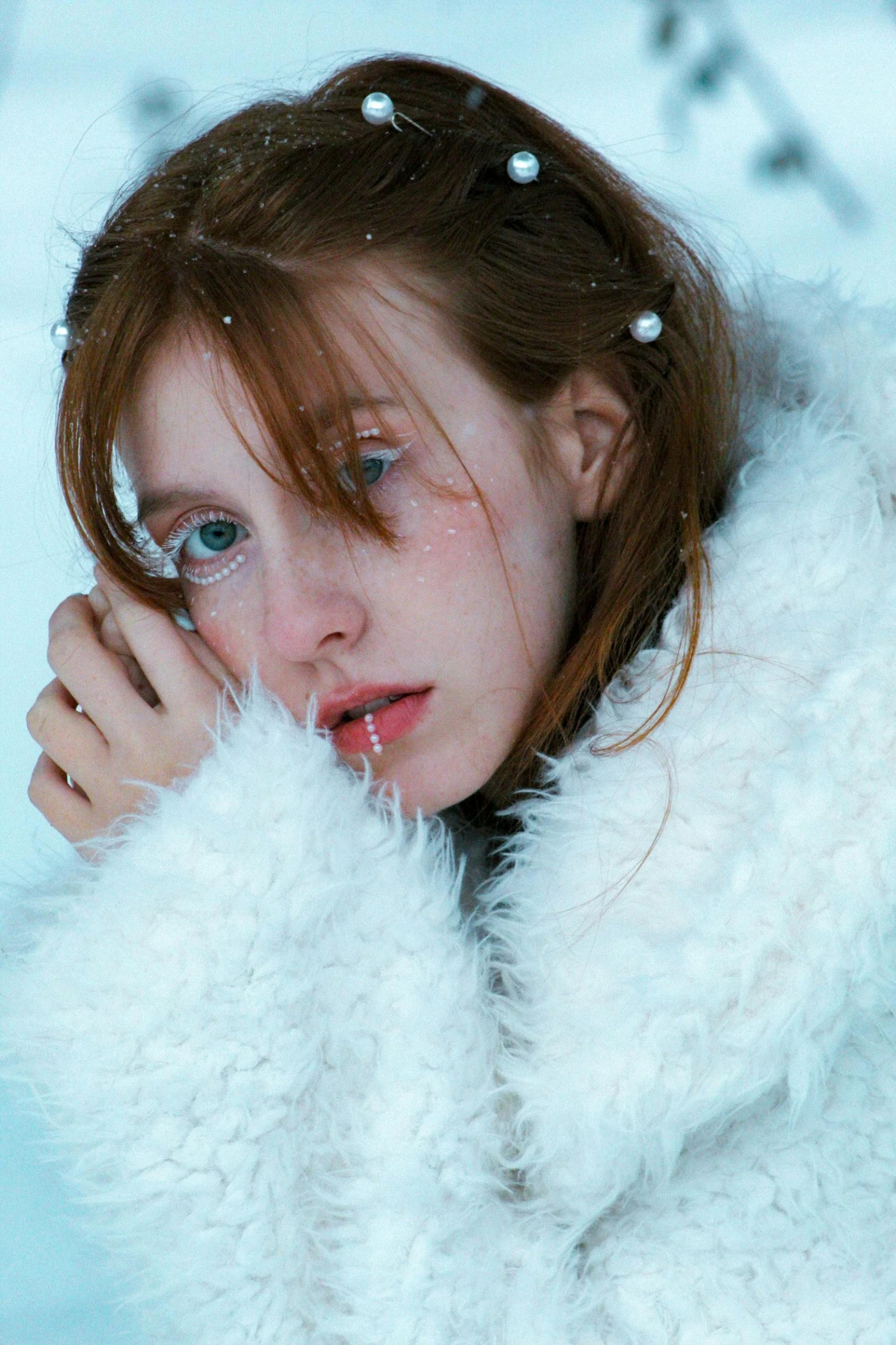 a young woman with glasses, white coat and earrings