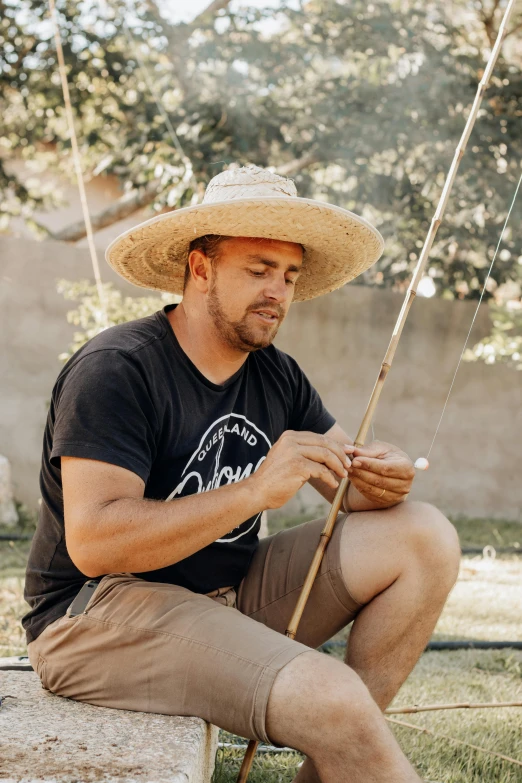 a man sits on a bench with a fishing pole