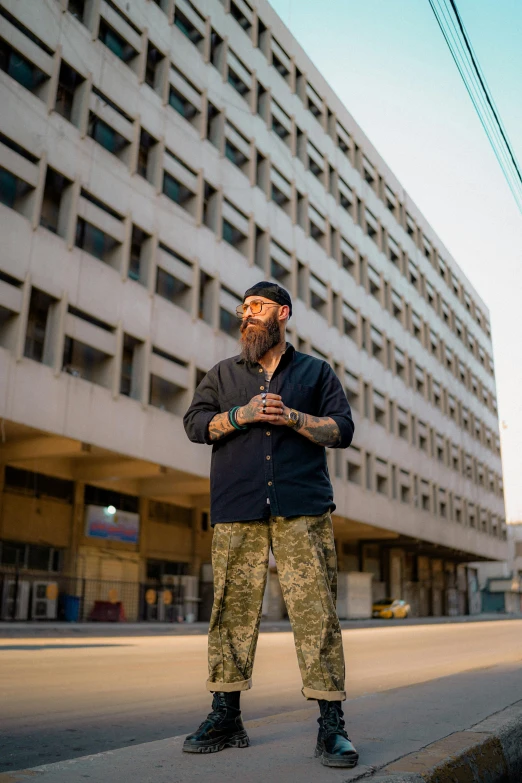 a man standing in front of a building on the sidewalk