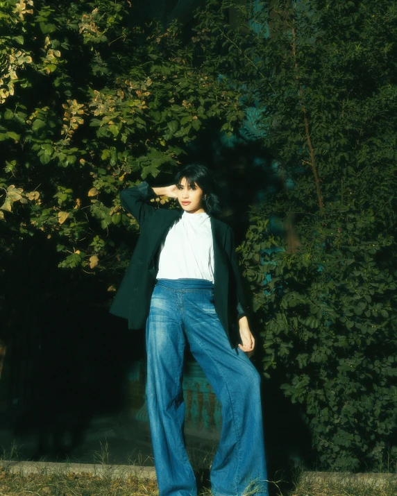 a woman standing in front of a tree posing for a po